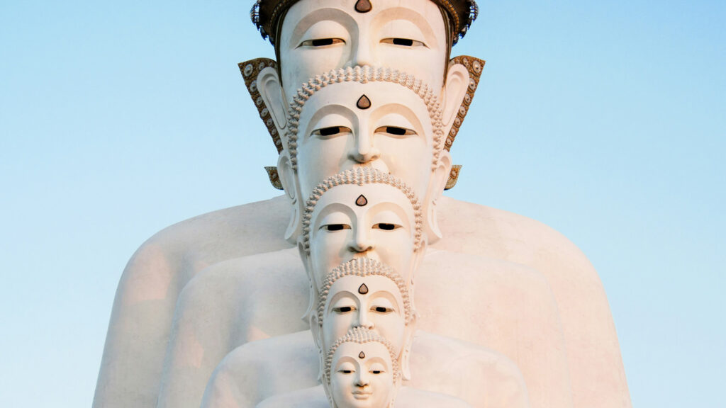 Four white Buddha statues lining up behind each other, each bigger than the previous one.