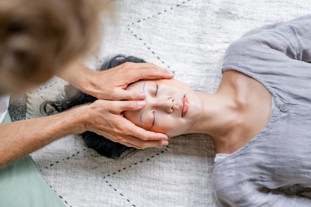 Massage therapist holding his clients head.